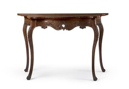 Ein geschwungener Wandtisch aus Nussbaumholz mit e
