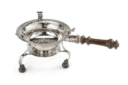 Un calentador circular de plata con bordes calados