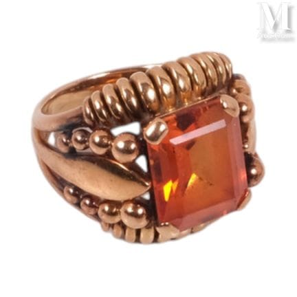 Gold ring with stylized motifs, featuring a semi-p