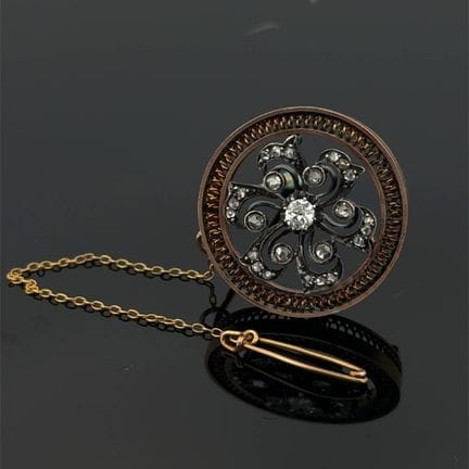 Broche circulaire en or jaune (750) et argent (min