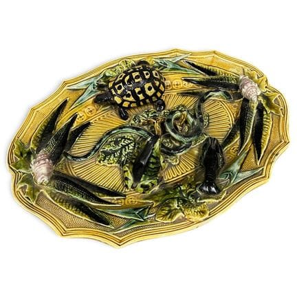 椭圆形多瓣陶盘，饰有浮雕图案，描绘了乌龟、青蛙、蛇、龙虾以及两枚贝壳，背景为叶片。这是一款仿帕利西风