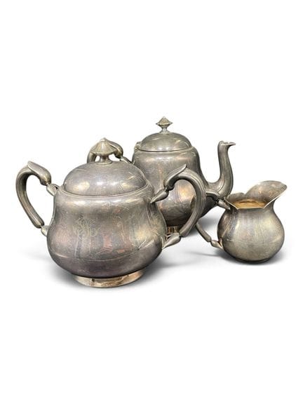 CHRISTOFLE
一套镀银的金属茶具，包括一只茶壶、一只糖罐和一只奶罐，饰有花卉图案，壶身带有编