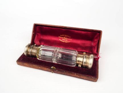 A cylindrical, faceted crystal salt shaker with tw