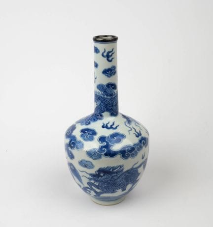 中国为越南所制——20世纪
瓷质栏杆式花瓶，釉下以蓝色装饰，瓶身描绘三只麒麟在波涛中奔腾，上方有一条