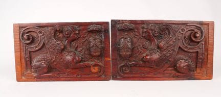 Two carved wooden panels depicting two sphinxes fa