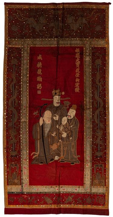 大型壁挂

中国，约1900年。天鹅绒、棉布和丝绸，绣有金属线，并镶有小镜片。三颗星神“三星”被吉祥