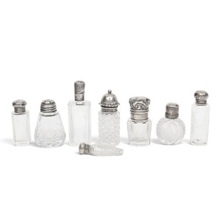 Eight small crystal-cut perfume bottles with silve