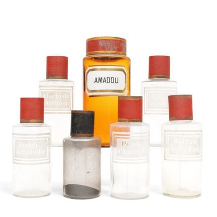 Sieben Apothekenflaschen aus Glas mit rot lackiert