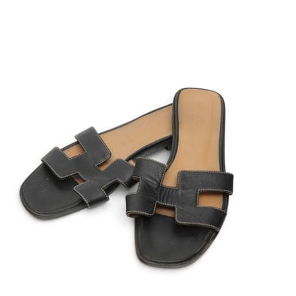 Hermès black leather Oran sandals. Showing signs o