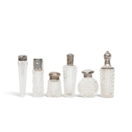 Five crystal-cut perfume bottles with silver caps,
