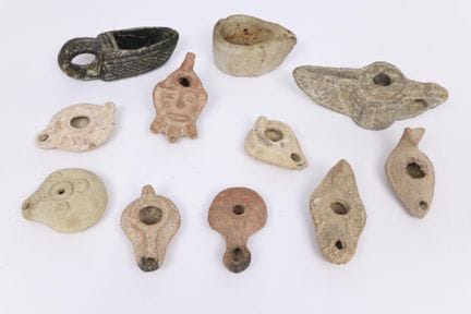 Una collezione di undici lampade a olio in pietra 