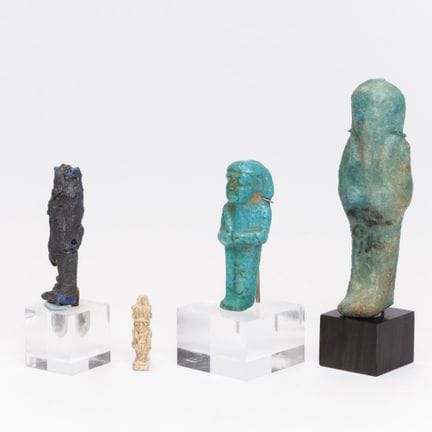 Egipto, dos ushabti de fayenza azul, un amuleto y 