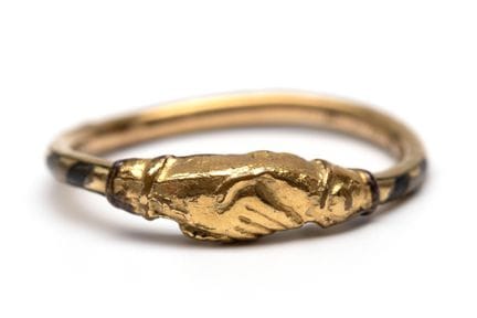 A rolled gold fede ring featuring two right hands 