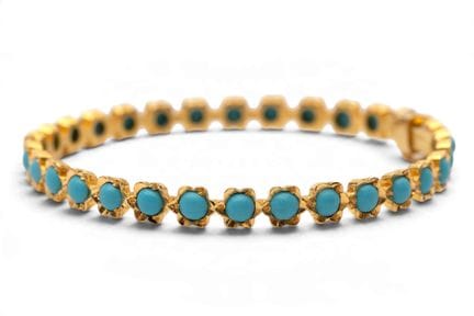 Una pulsera de oro con gemas engastadas. Compuesta