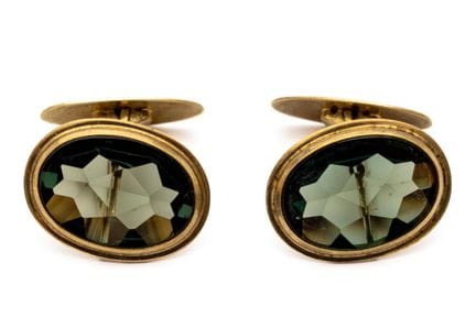 A pair of oval cufflinks. Each set features a buff