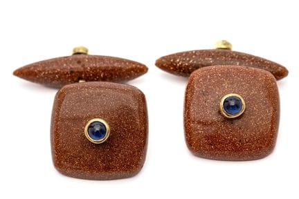 A pair of goldstone cufflinks. The front features 