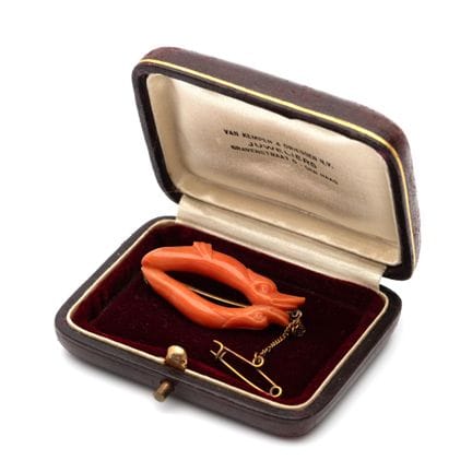 A 19th-century carved coral brooch depicting two d