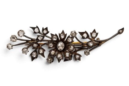 A diamond flower brooch in the shape of a branch w