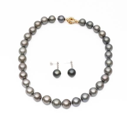 Un collar y unos pendientes de perlas. El collar e