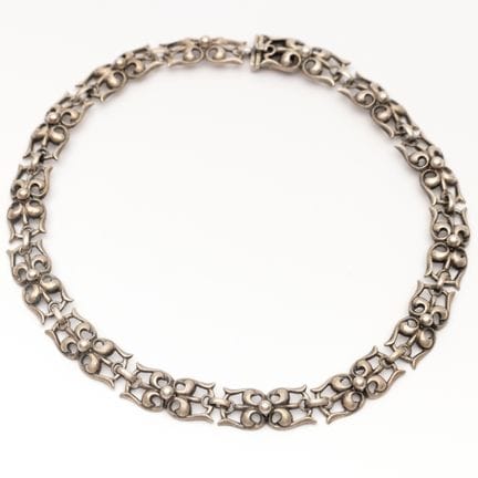 Un collier ras du cou ajouré en argent signé Regge
