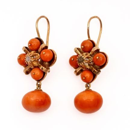A pair of coral earrings. The top is shaped like a