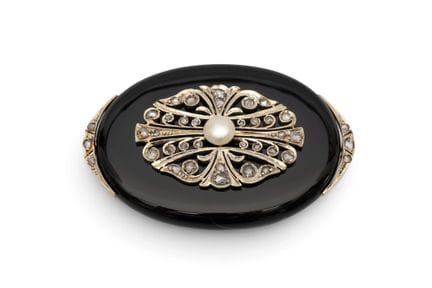 Une broche en onyx et diamants, avec des appliqués