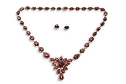 A modern garnet rivière necklace with matching ear