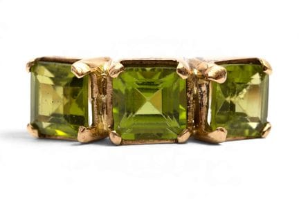Une bague à trois pierres en péridot. Sertie de tr