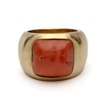 Un anillo de coral con un coral tallado en forma d