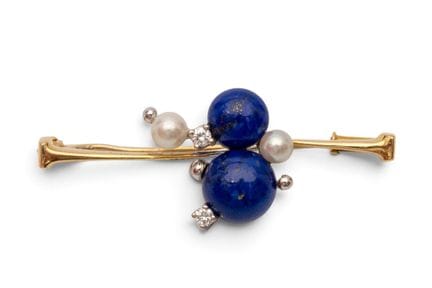 Une broche en forme de barre sertie, réalisée par 