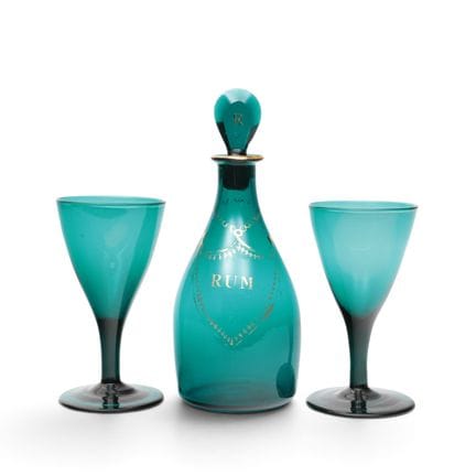 Caraffa in vetro verde e due calici da vino, stile