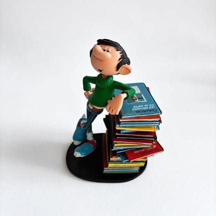 COLLECTOYS
Gaston leaning on a stack of comic book