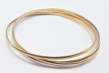 Trois bracelets joncs rigides entrelacés trois ton