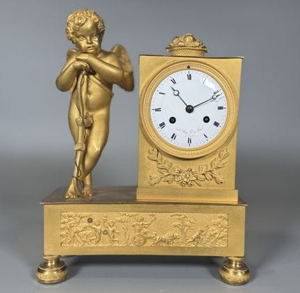 PENDULE en bronze doré et ciselé figurant un cupid