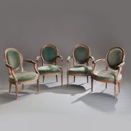 A set of four armchairs with medallion-shaped back
