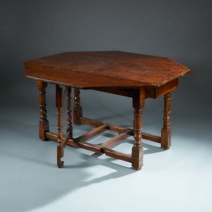 Large gate-leg table made of wood stained to resem