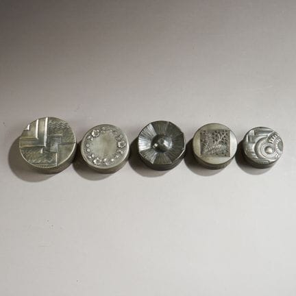 Set of five circular pewter boxes with repoussé de