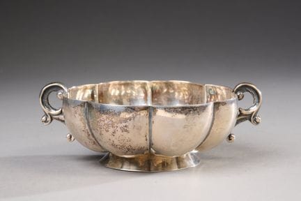 A circular, fluted bowl with two scroll-shaped han