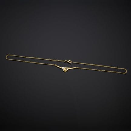 Collier en métal doré, présentant un motif central