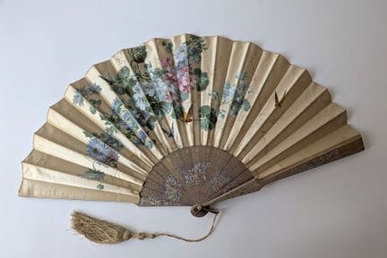 Folded fan; the wooden ribs are partially painted 