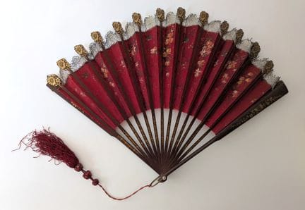 Folded fan; the wooden ribs are partially decorate