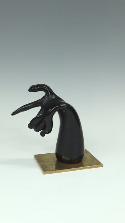 作品《手》，埃尔温·艾施（Erwin Eisch），1970年。黑紫色自由形态玻璃。置于带抛光金饰的