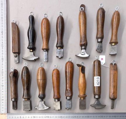 15 outils de cordonnier bourrelier sur le socle en