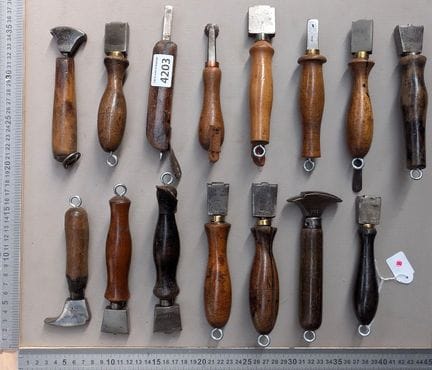 15 outils de cordonnier bourrelier sur le socle en