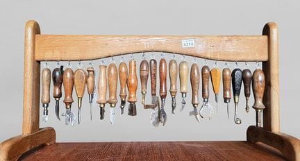 15 outils de cordonnier bourrelier sur le socle en