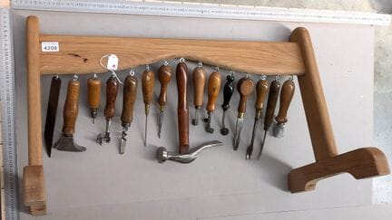 15 outils de cordonnier bourrelier sur le socle en
