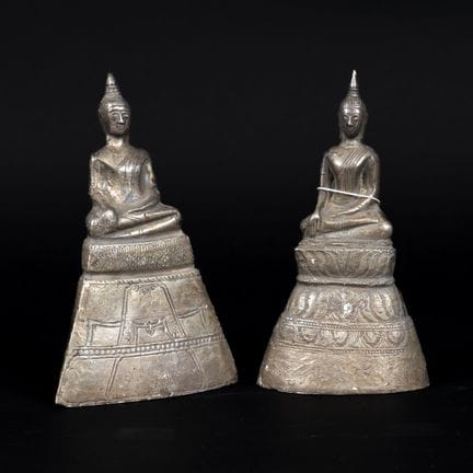 泰国，20世纪。两尊佛像端坐于高基座上，呈“指地印”姿势。木芯覆银箔。高：约15.5厘米。