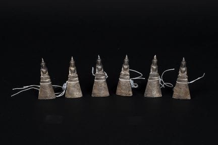泰国，20世纪。六尊佛像端坐于高高的基座上，呈“指地印”姿势。木芯上覆银箔。高：约6.5厘米