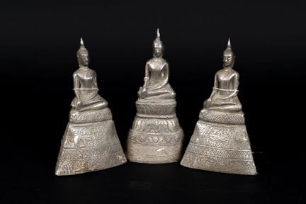 泰国，20世纪。三尊佛像端坐于高高的基座上，呈“指地印”姿势。木芯上覆银箔。高：约15.5厘米。