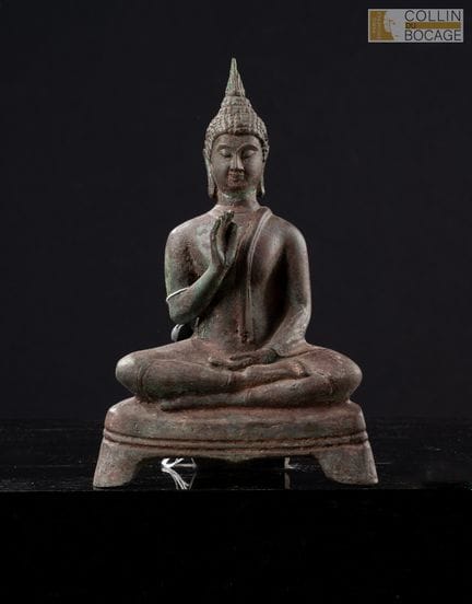 泰国，19-20世纪。佛像端坐于三足基座上，正做出转动法轮的手势。青铜材质，表面呈现棕、红、绿色包浆